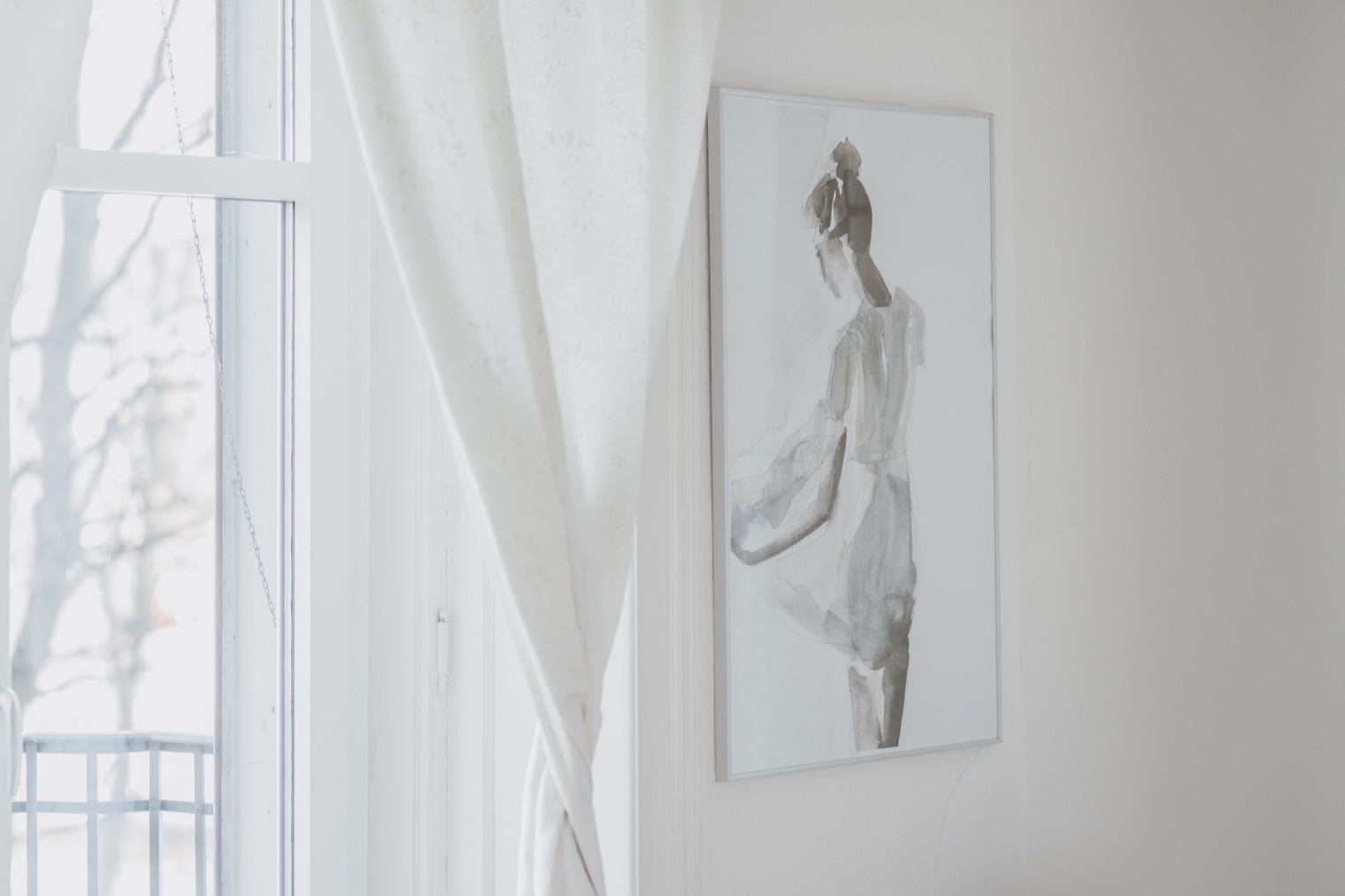 Helles Fenster mit Vorhang und einem gerahmten Aquarell einer Frau.